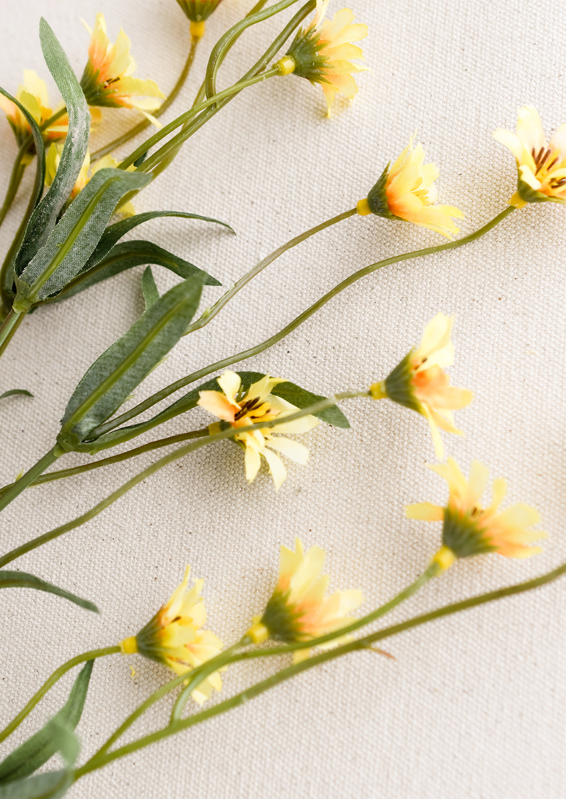 A faux flora spray of yellow wild daisy.
