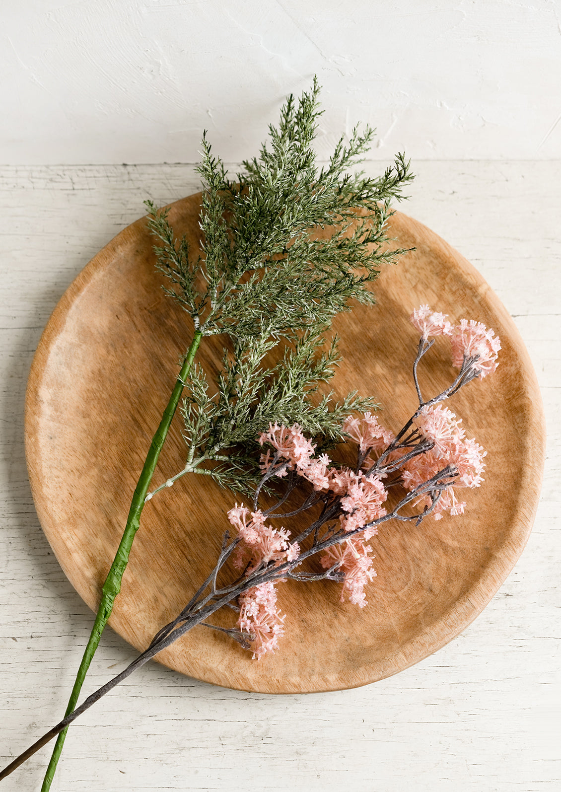 Faux stems on a wooden platter.