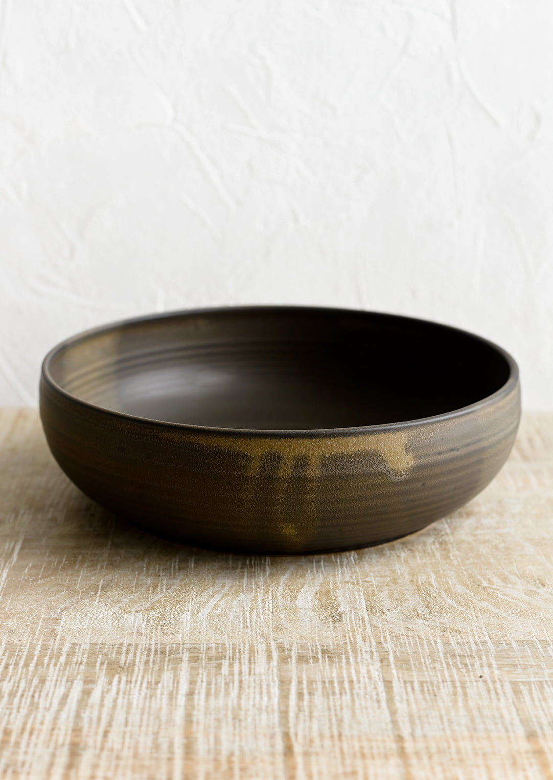 A ceramic serving bowl in matte brown.