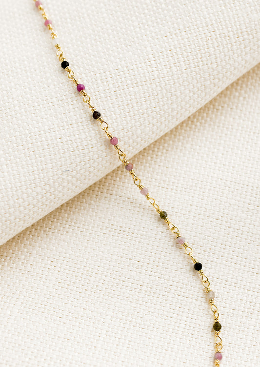 A gold wire bracelet with small multicolor tourmaline beads.