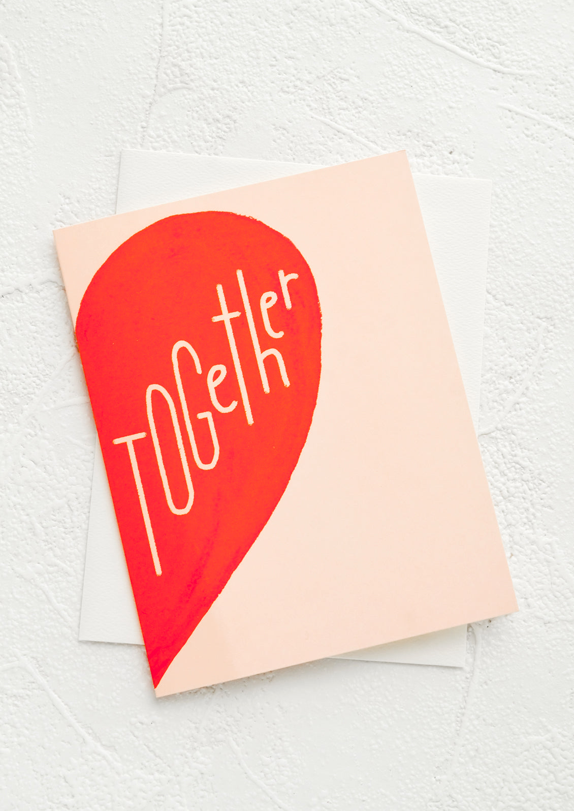 A greeting card with image of half of a red heart and text reading "Together".