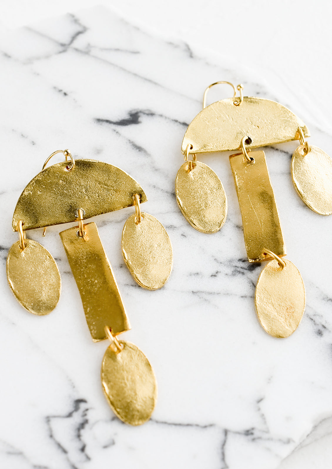 A pair of gold drop earrings in tiered chandelier shape.