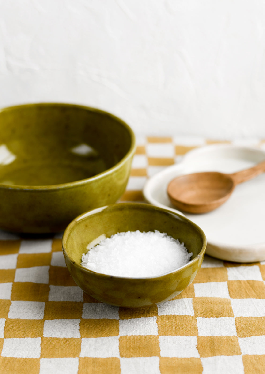 Green ceramic bowls with salt in small bowl.