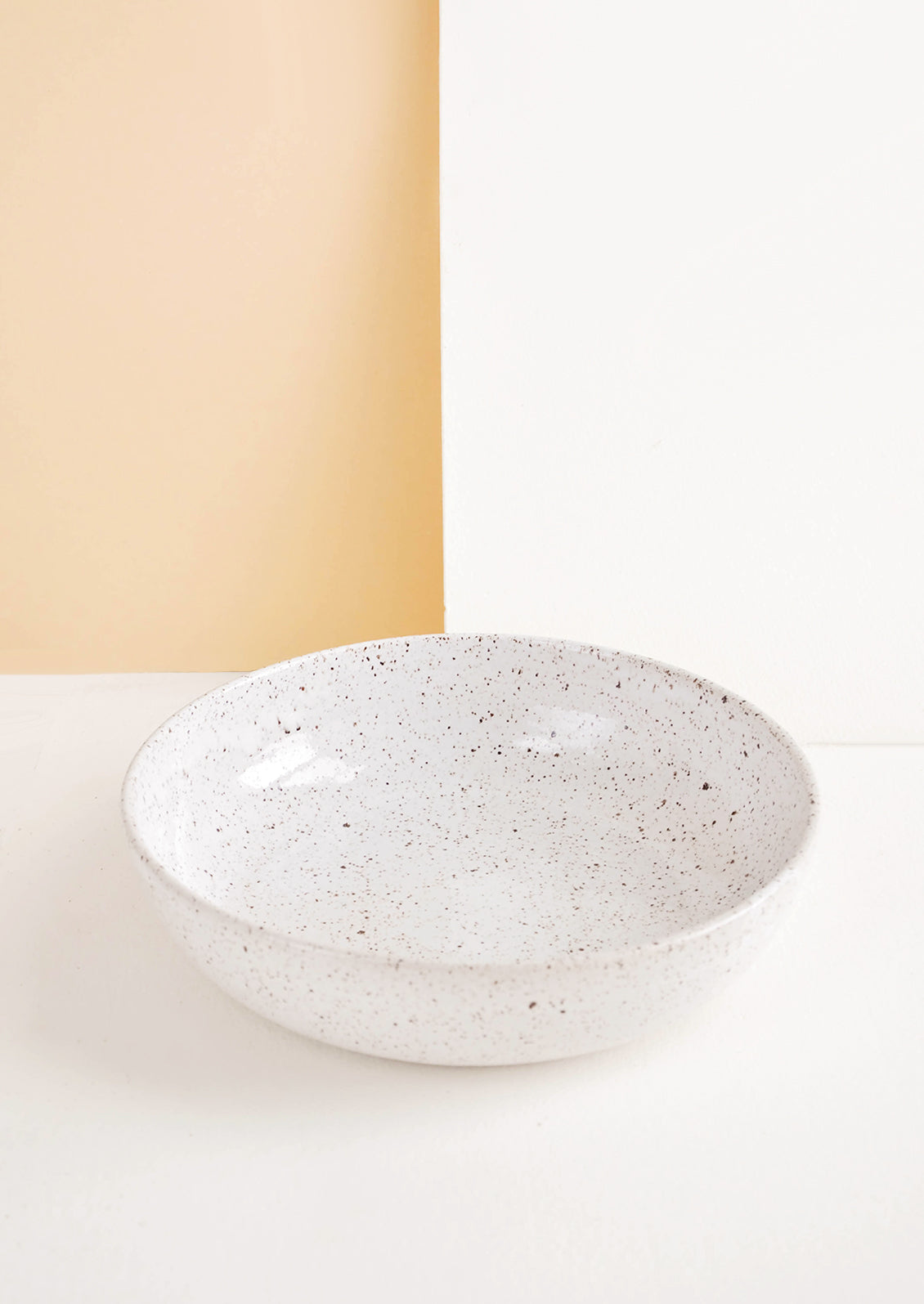 Shallow ceramic bowl, ideal for pasta, in white glaze with brown speckles.