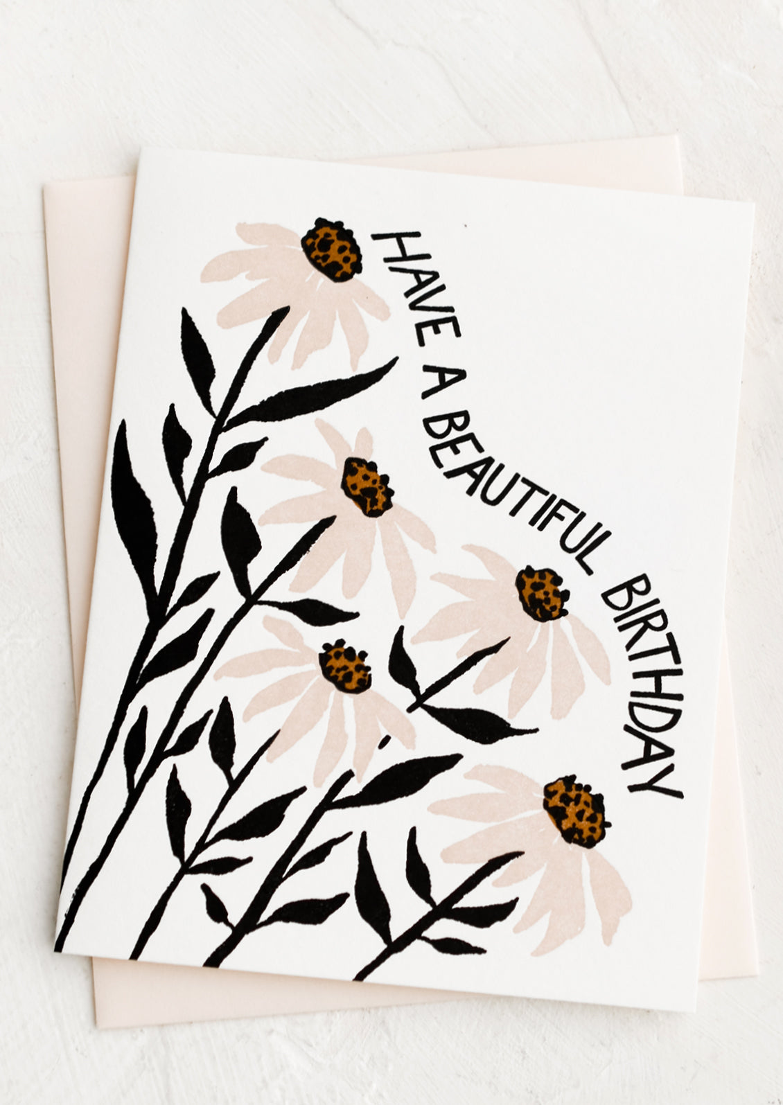 A greeting card with pink and black coneflower print, text reads "Have a beautiful birthday".