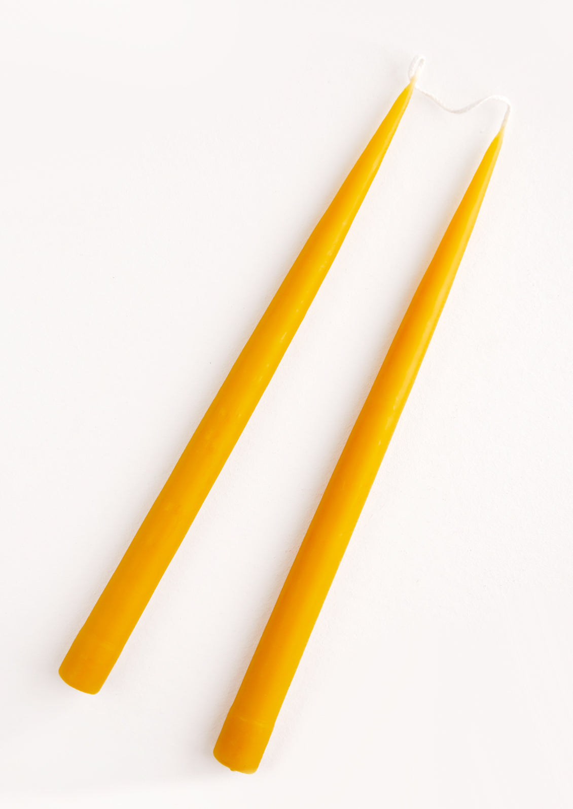 Pair of Two Taper Candles in honey yellow.