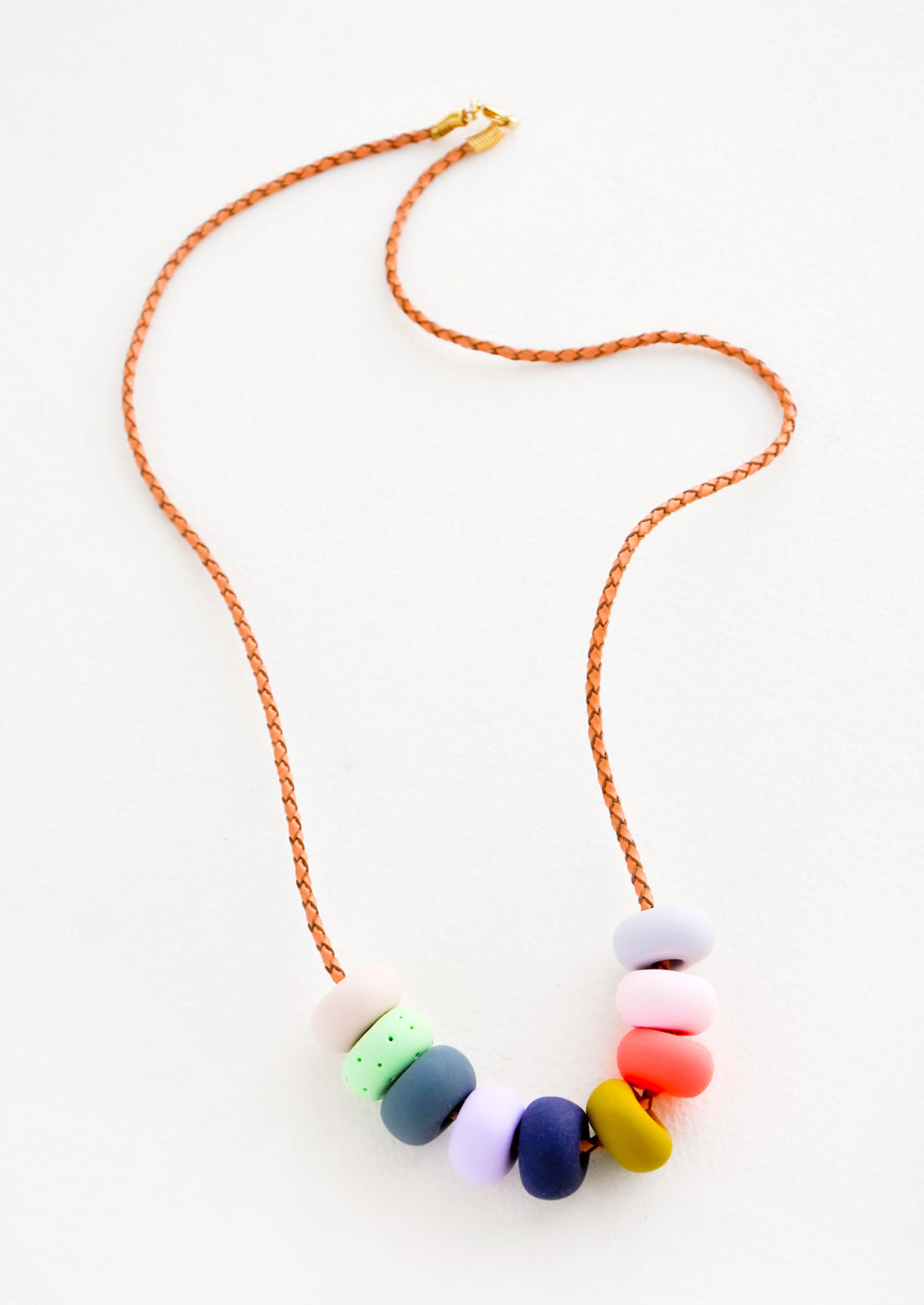 Woven leather cord necklace with gold clasp and rounded clay beads red, blue, lime green and mustard yellow.
