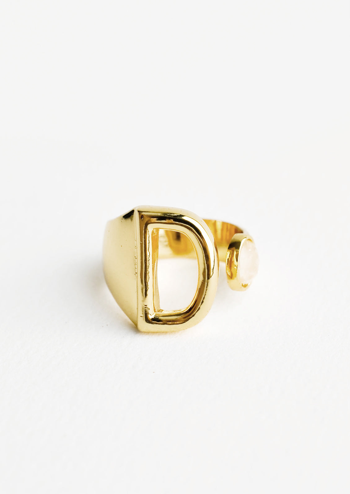 Yellow gold ring with letter D and oval glass crystal, and wide adjustable band.