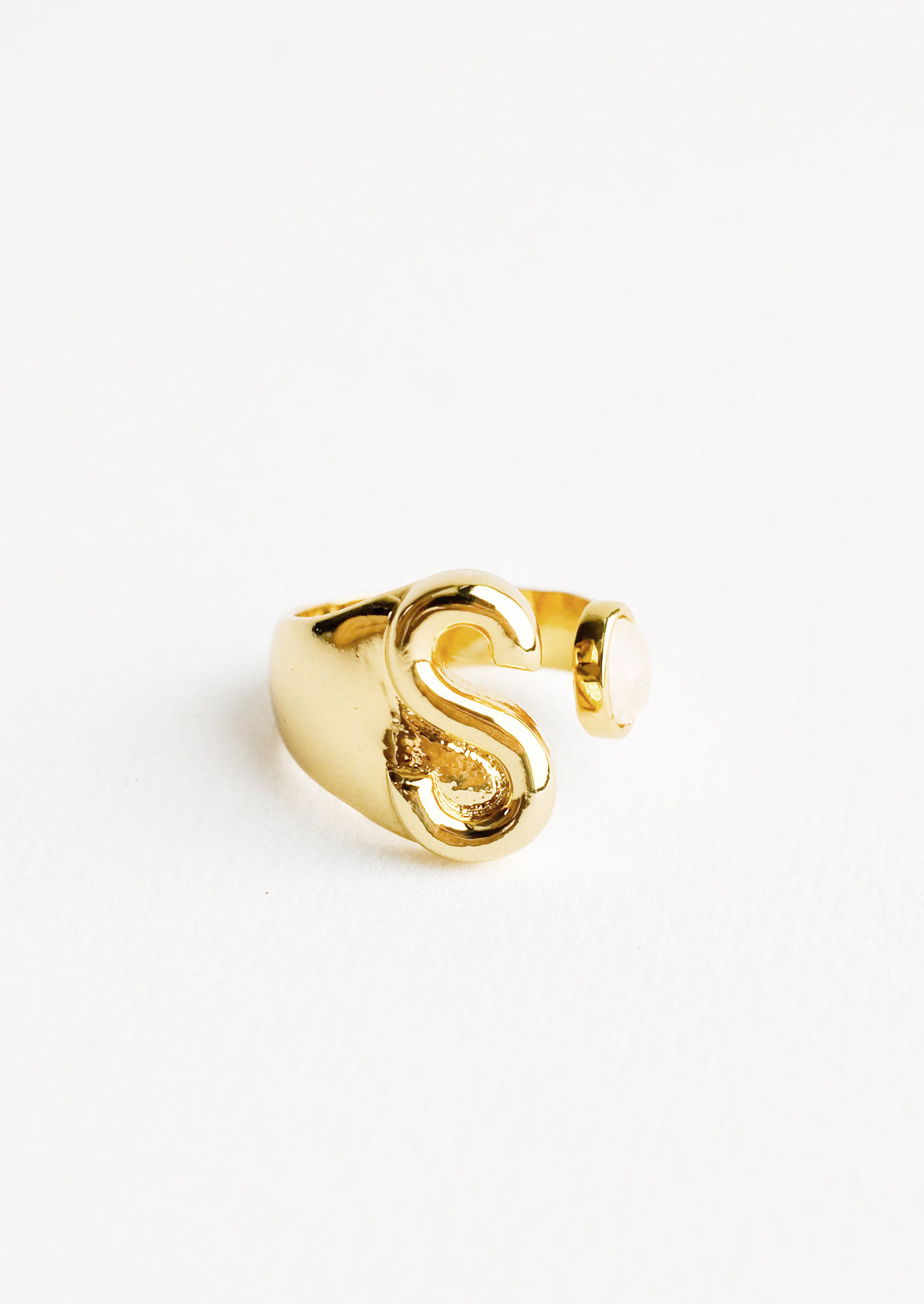 Yellow gold ring with letter S and oval glass crystal, and wide adjustable band.