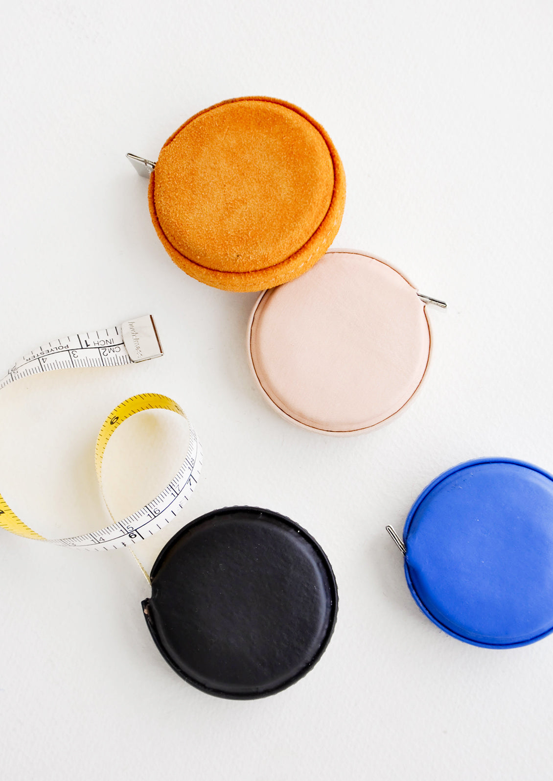 Product shot featuring multiple styles of leather covered tape measures.