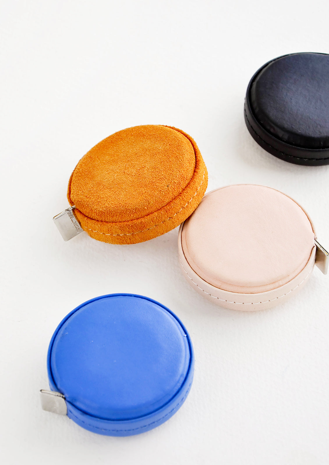 Product shot featuring multiple styles of leather covered tape measures.