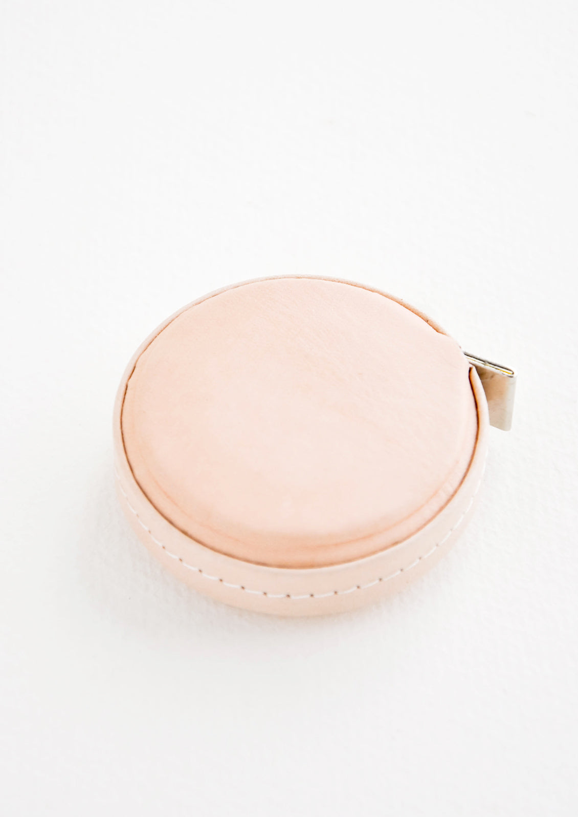 Tape measure covered in natural leather.