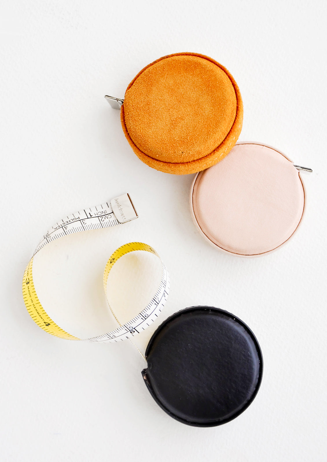 Product shot featuring multiple styles of leather covered tape measures.