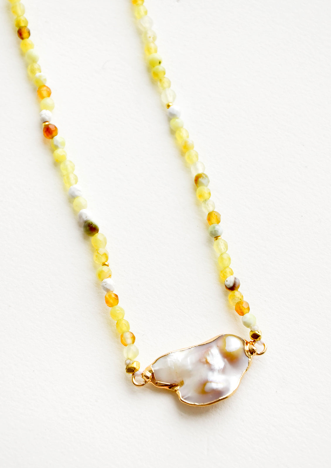 Gemstone beaded necklace in shades of yellow with asymmetrical grey pearl pendant at front