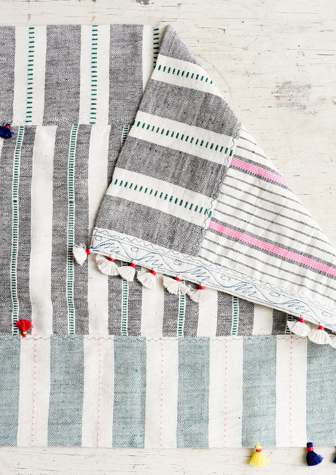 A madras stripe placemat in multicolor with tassel detail.