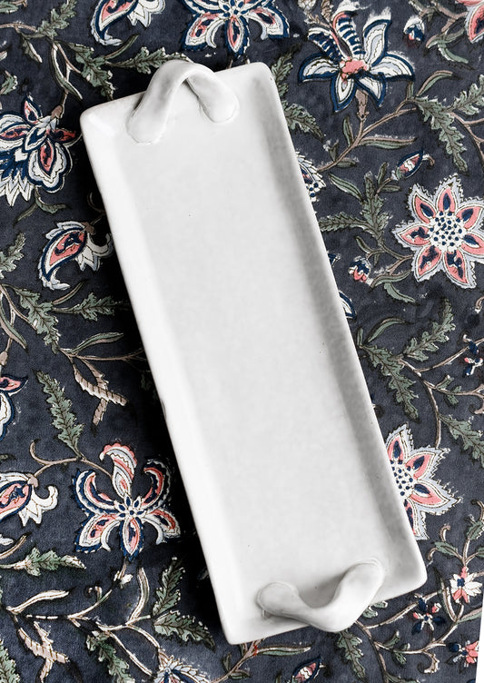 Long and skinny ceramic tray with side handle detail.
