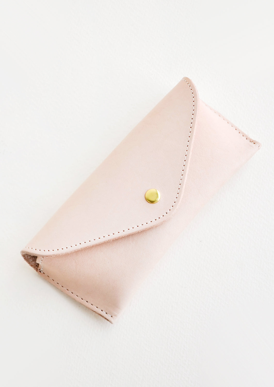 Pale pink leather case for sunglasses that folds close with a snap.