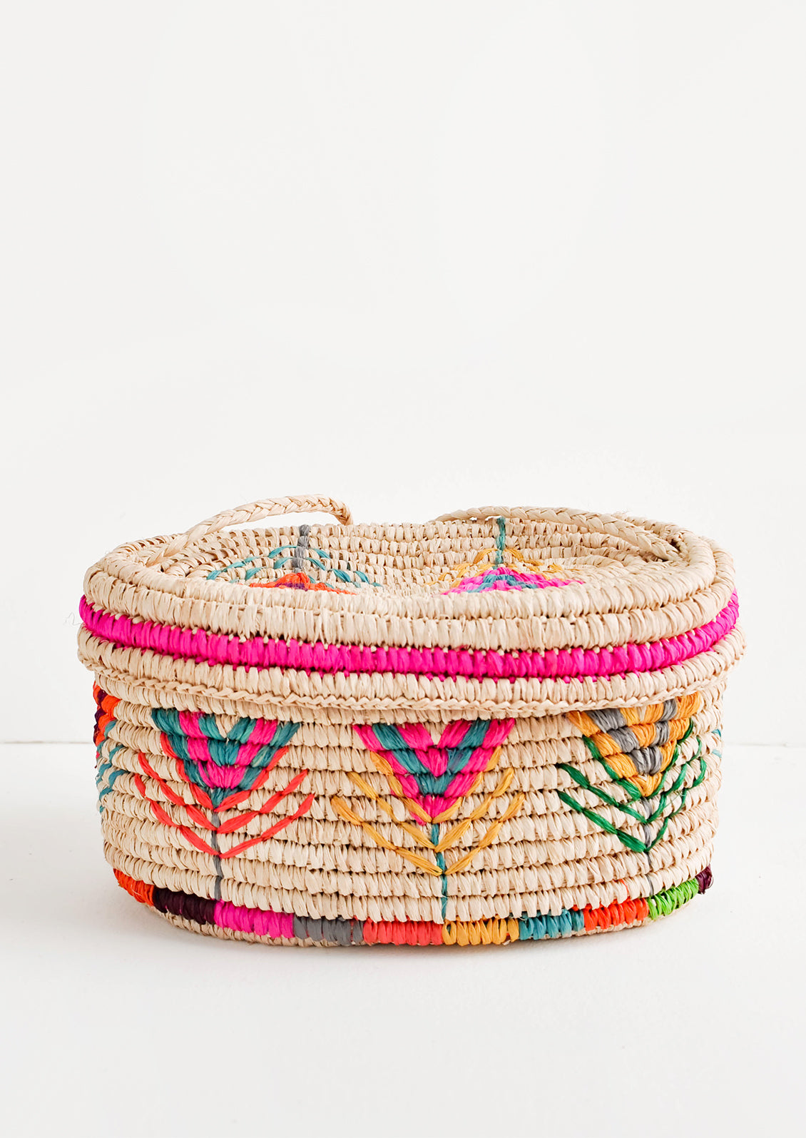 Rounded box style straw bag with neon multicolored flower pattern.