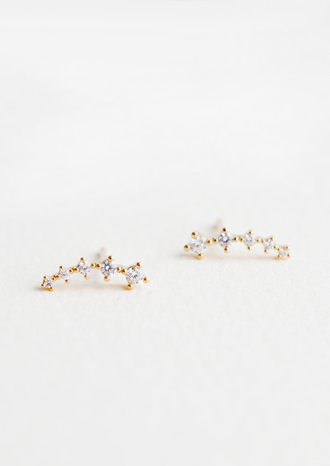 Stud earrings with clear crystals in incremental sizes, designed to climb up the ear