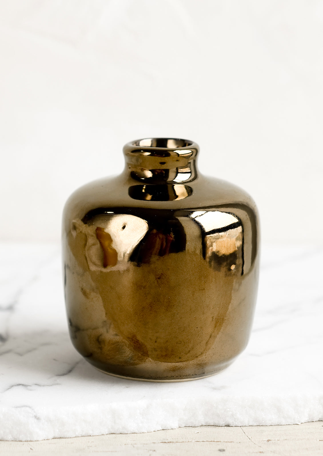 A ceramic bud vase in short shape, bronze color.