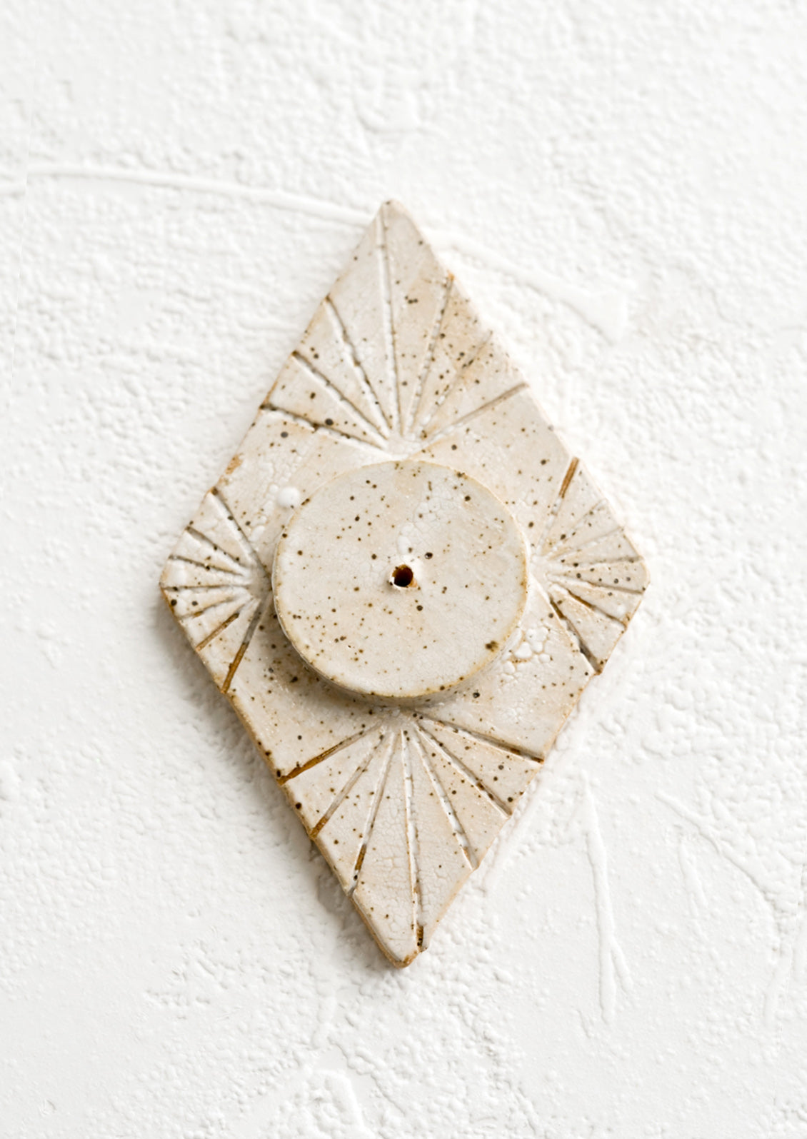 A ceramic incense holder in diamond shape.