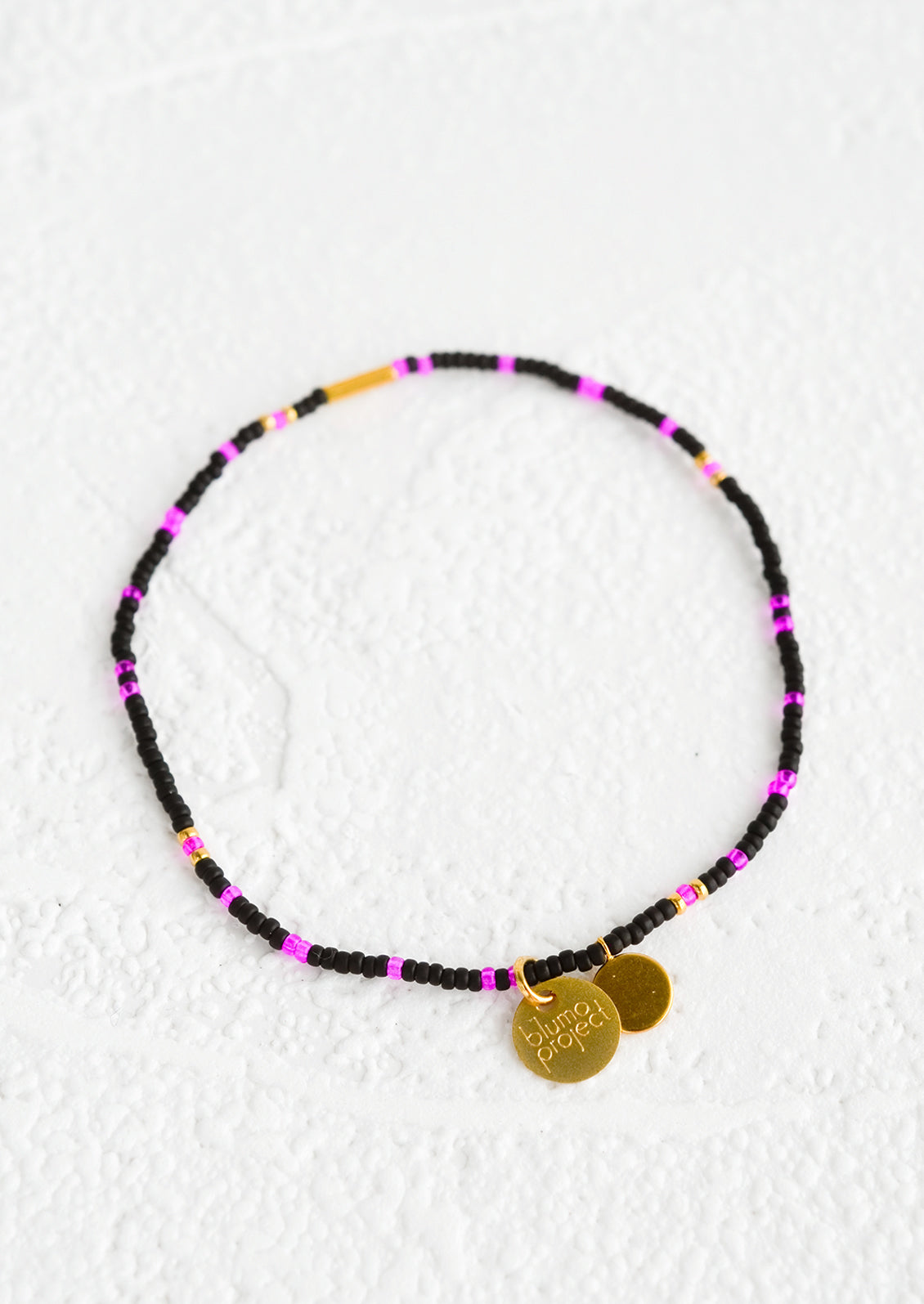 Seed bead bracelet in black and neon pink with brass accents