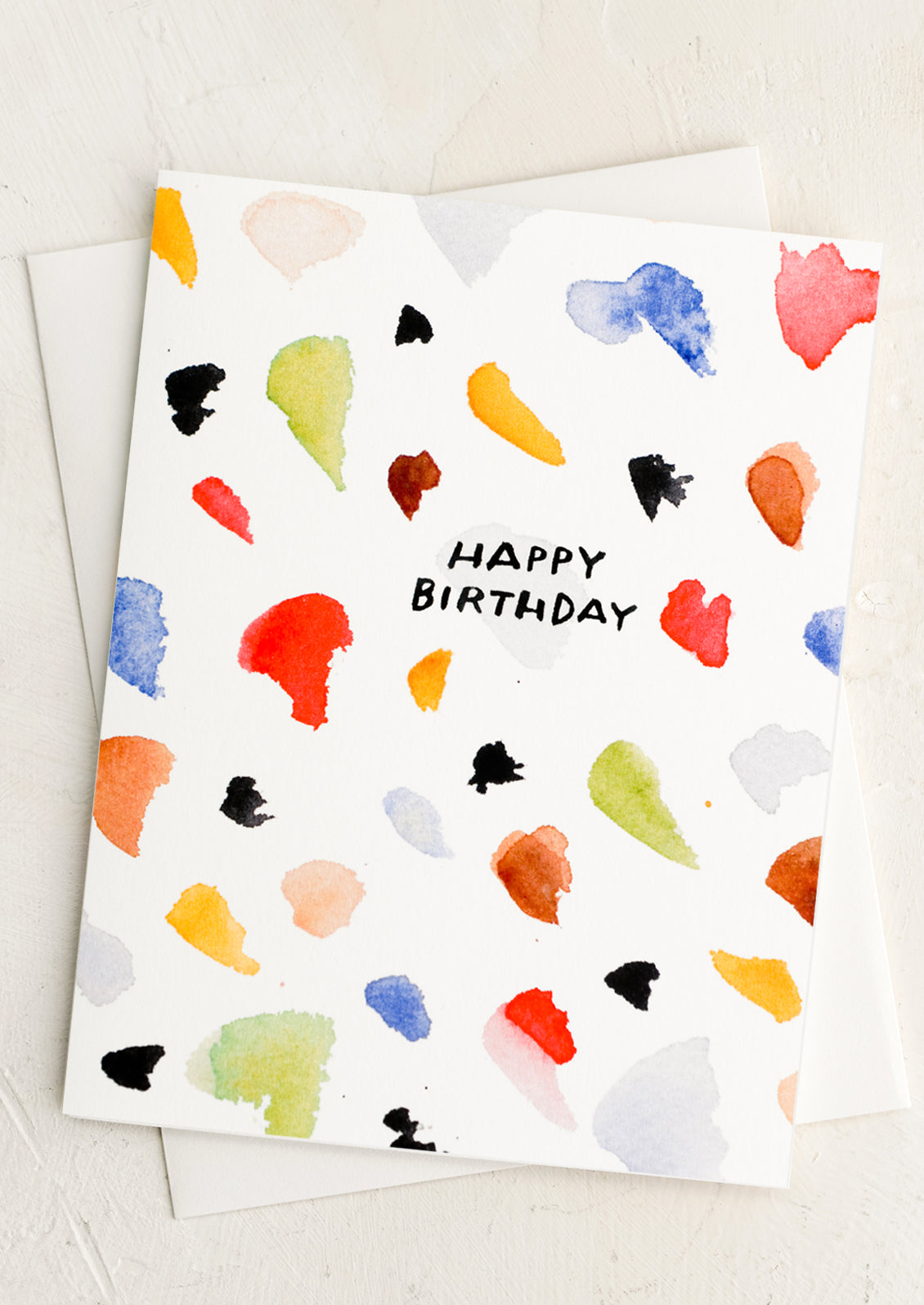 A card with paint stroke design reading "happy birthday".