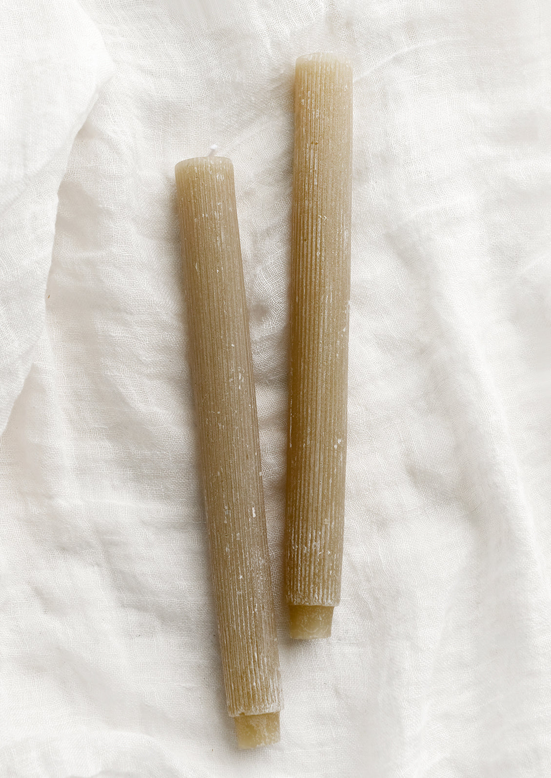 Taper candles with fine ribbed texture in linen tan.