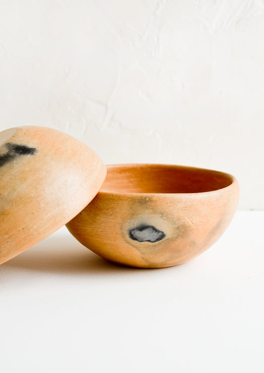 A red clay bowl with black scorch marks.