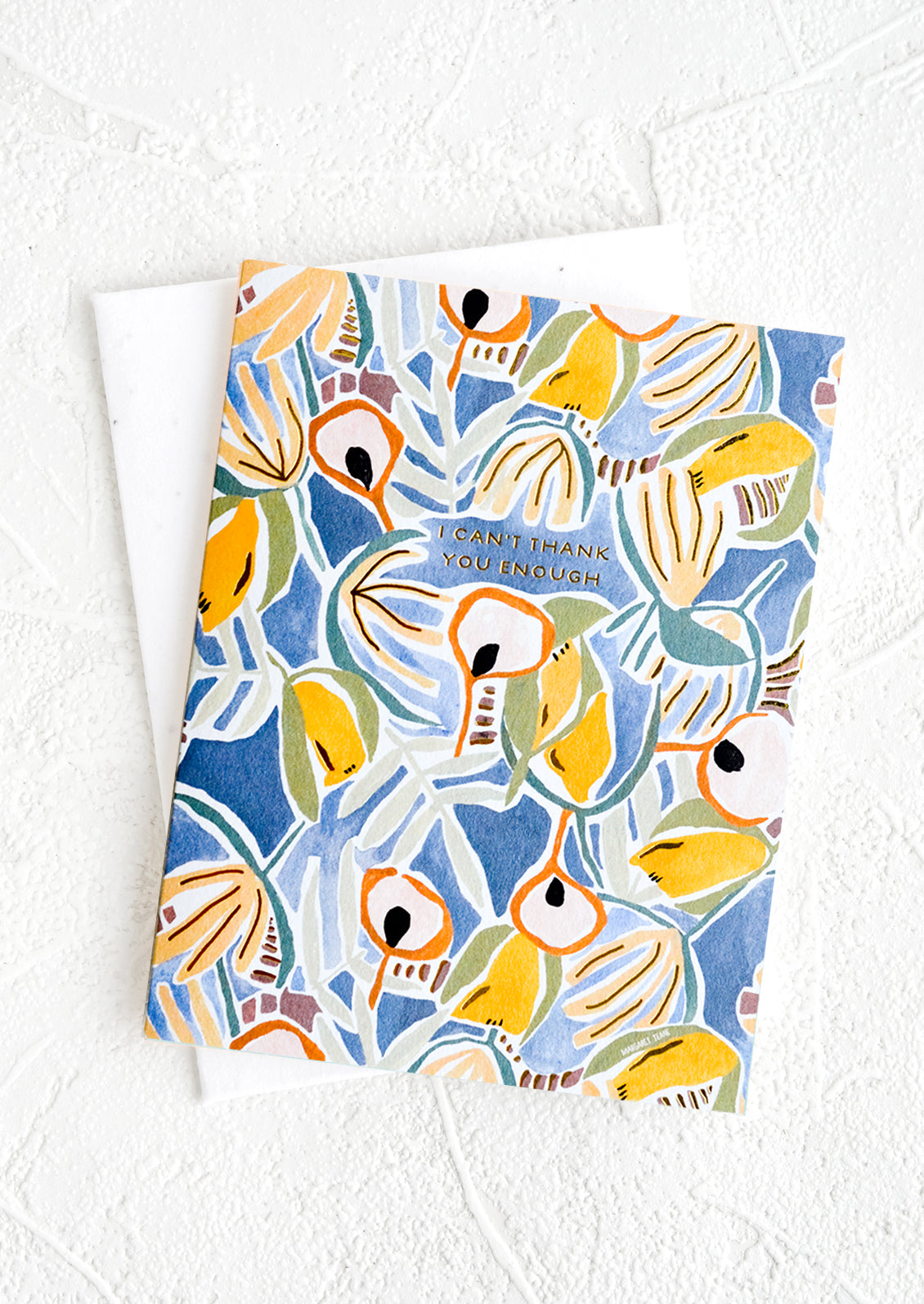 A greeting card with blue and yellow floral background with small gold lettering at center reading "I can't thank you enough"