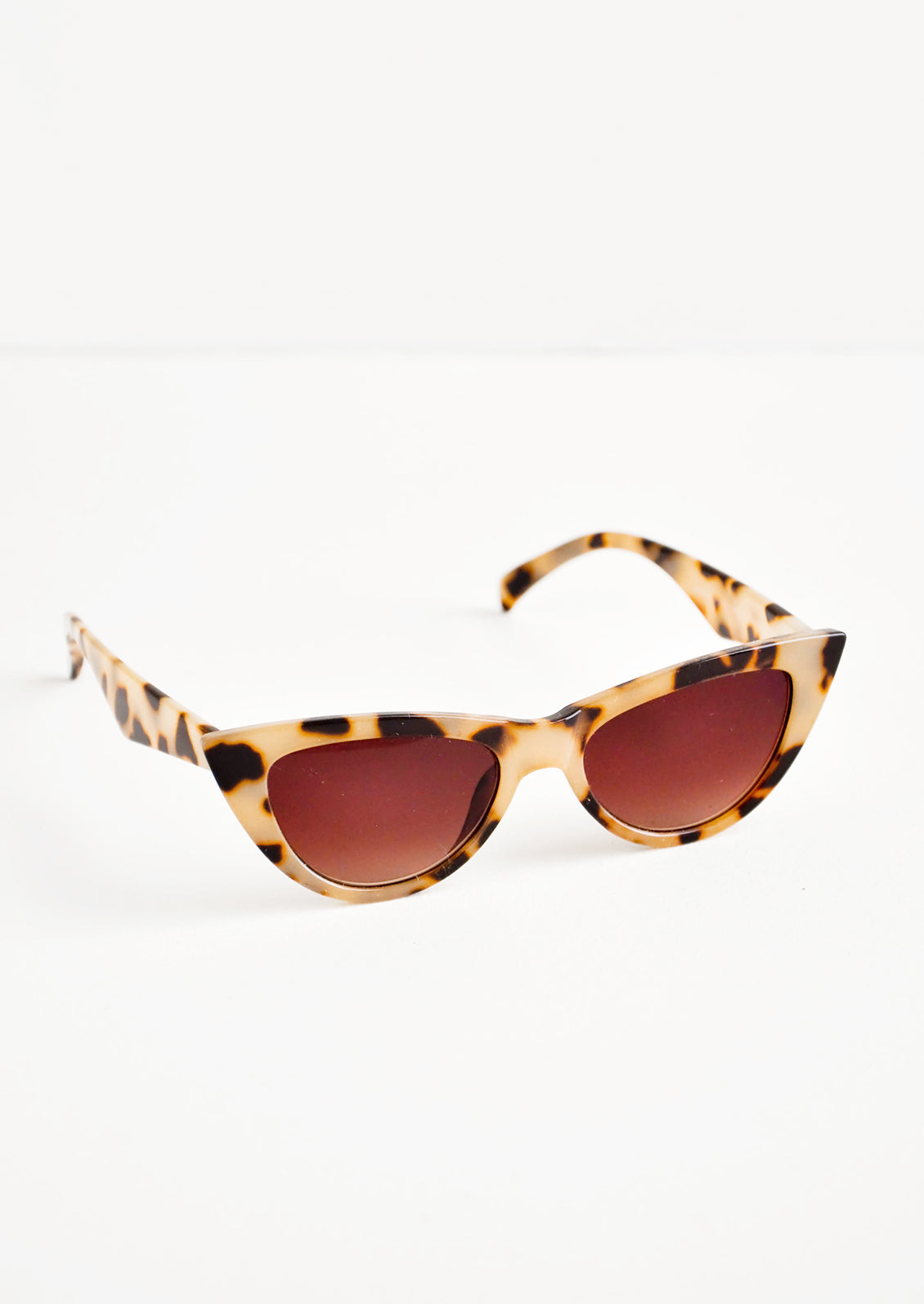Cat eye sunglasses with tortoiseshell frame and tinted lenses.