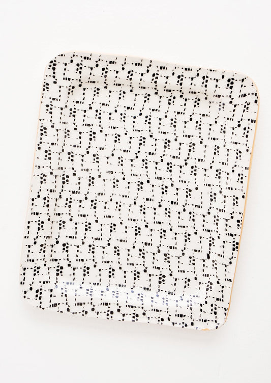 A rectangular ceramic tray with black and white patterned finish.