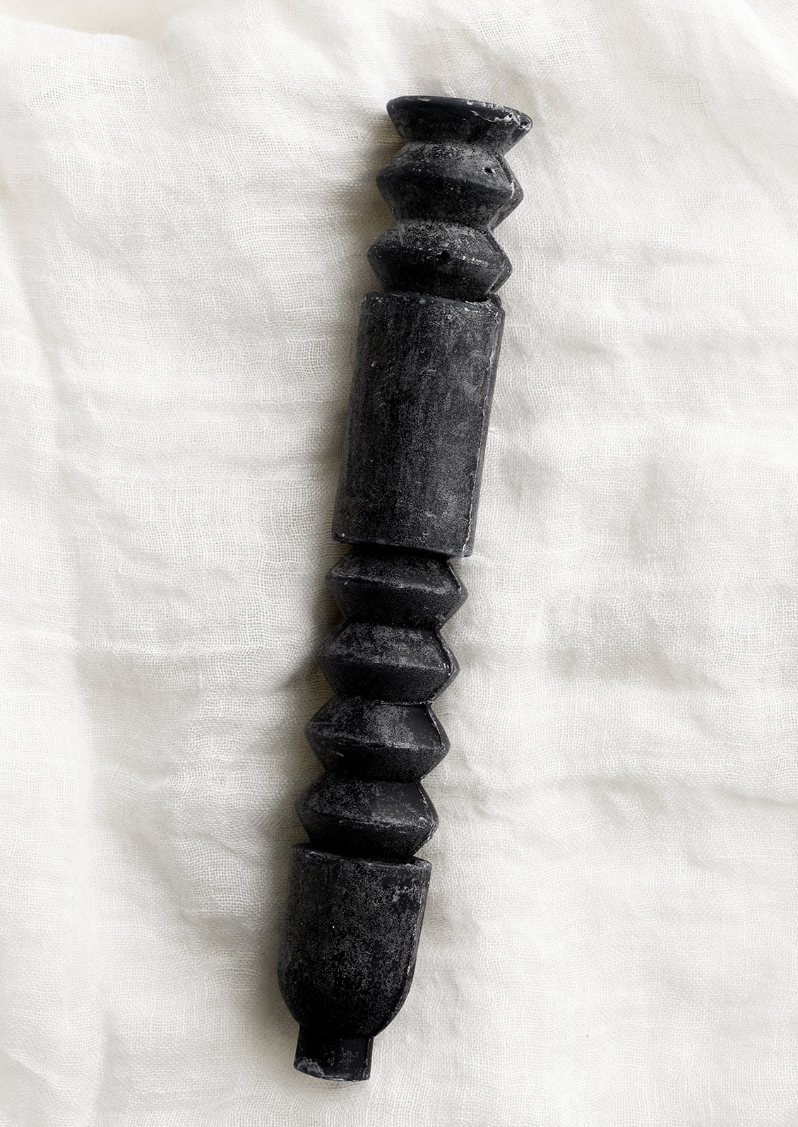 A geometric shape taper candle in black.