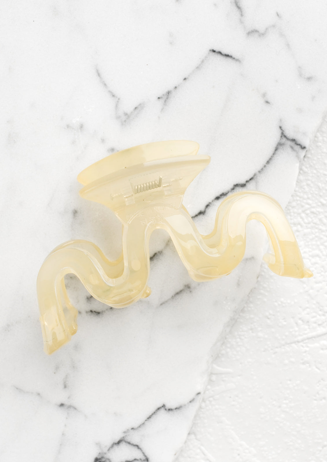 A wavy squiggle hair claw in pale banana.